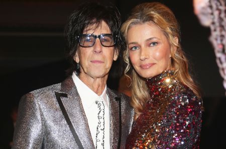 Paulina Porizkova in a red dress poses with her late-husband Ric Ocasek at an event. 